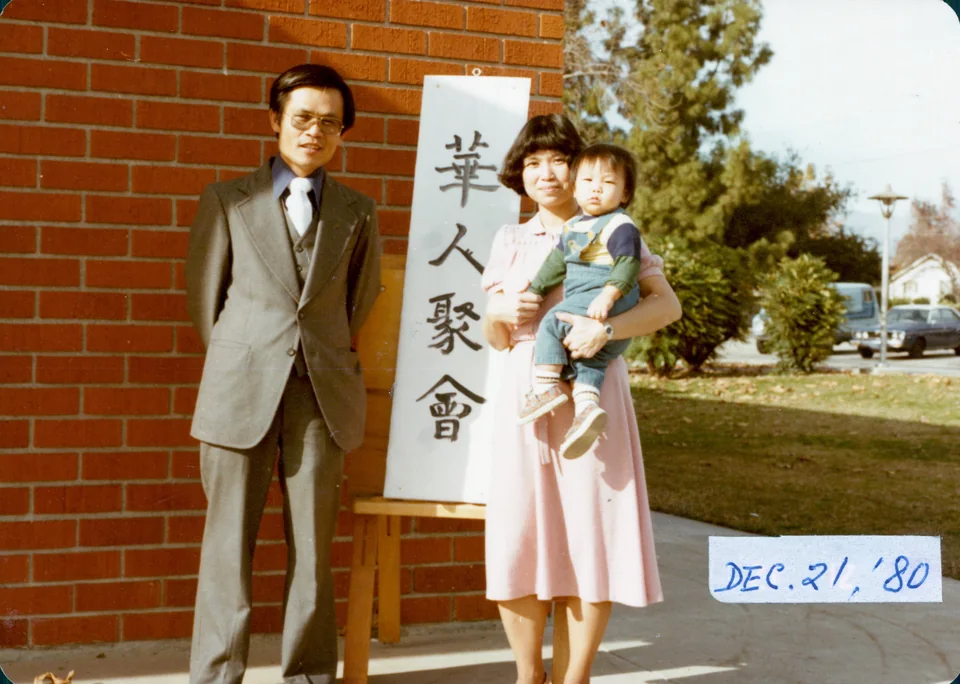 David, Esther and baby Angell beside the sign for the Chinese gathering in Pomona, 21 December 1980. Identified by Angell; the date is printed on the photograph.