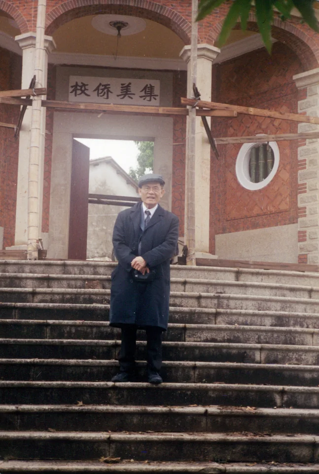 On the steps of a gate lettered 集美僑校, the Jimei Overseas Chinese School, Xiamen. From the family’s “2003 Mission to China” photographs.