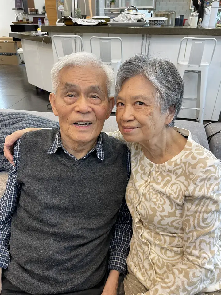 An older man and woman seated closely together